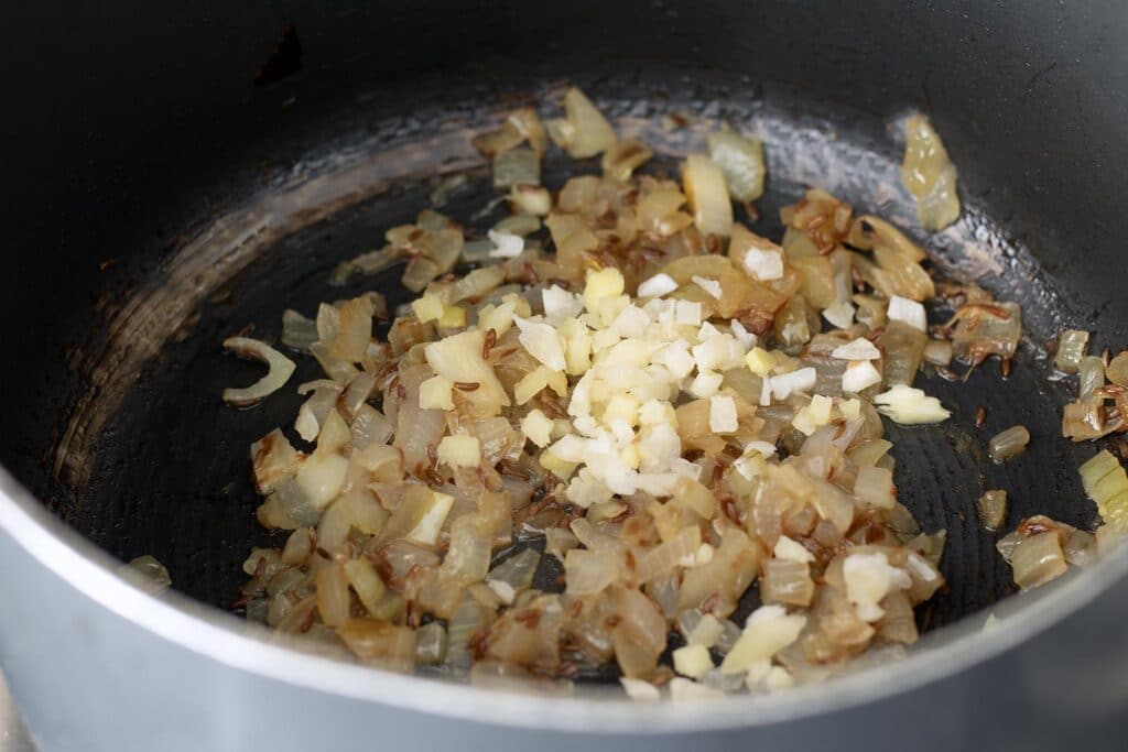 chopped onions in pan with garlic and ginger