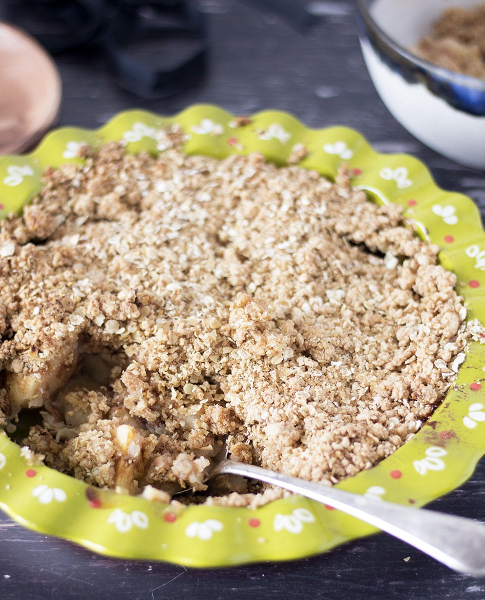 apple crumble in pie dish with spoon