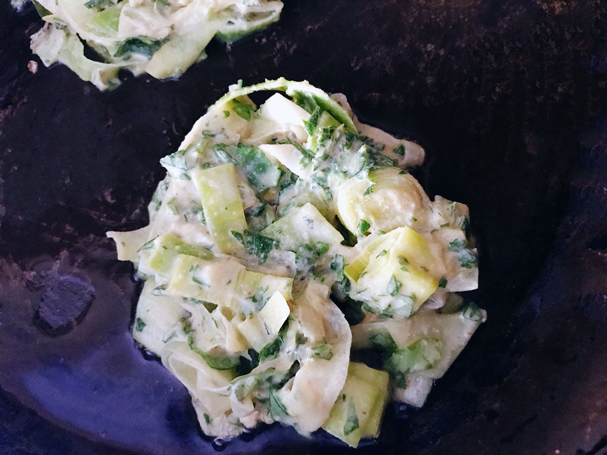 uncooked leek and herb fritter in frying pan