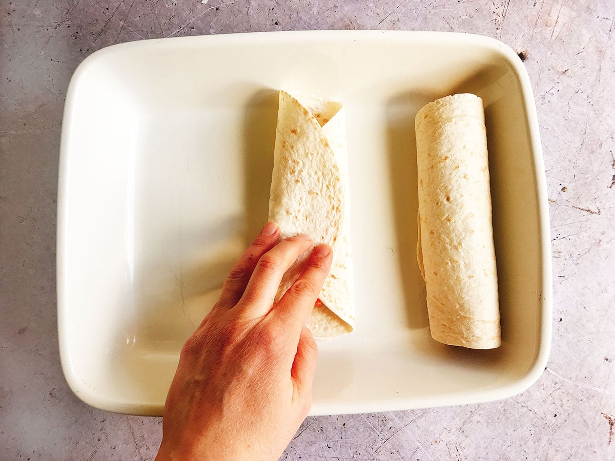 how to make black bean enchiladas - rolling up tortilla