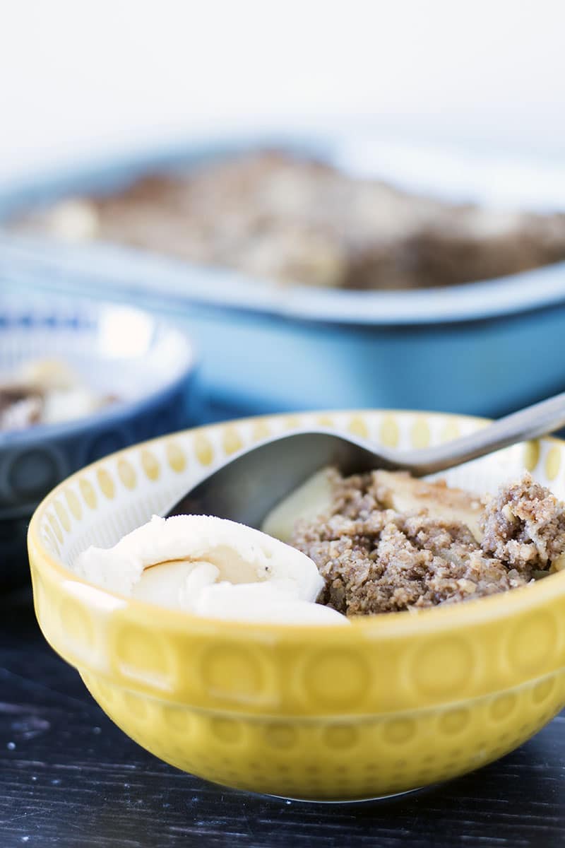 healthy apple crumble in yellow and blue bowls