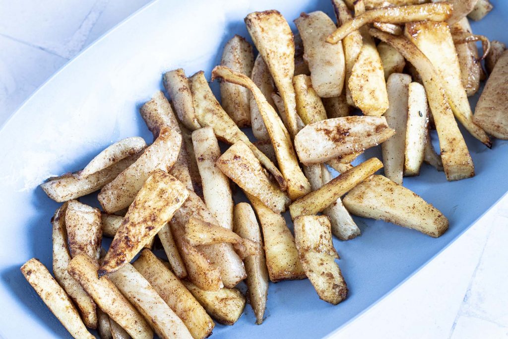 roasted parsnip and turnip wedges on blue platter