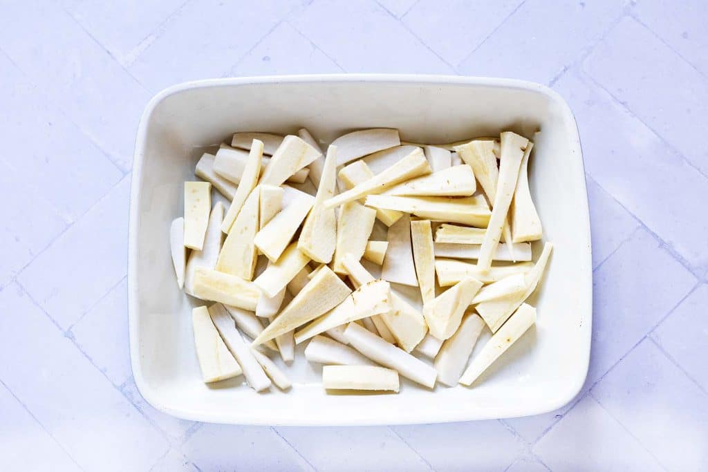 raw parsnip and turnip in roasting tray