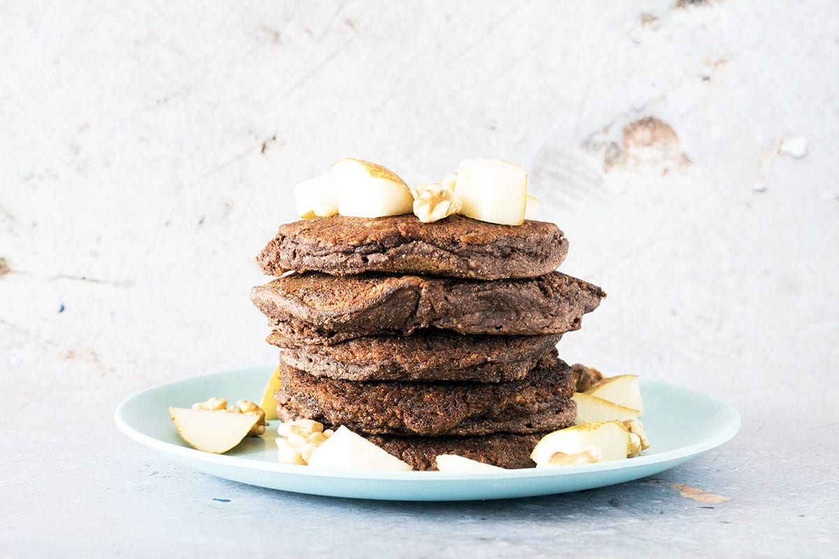 stack of pear, chocolate and coconut flour pancakes on blue plate