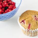 close up of a redcurrant muffin and blue bowl with redcurrants