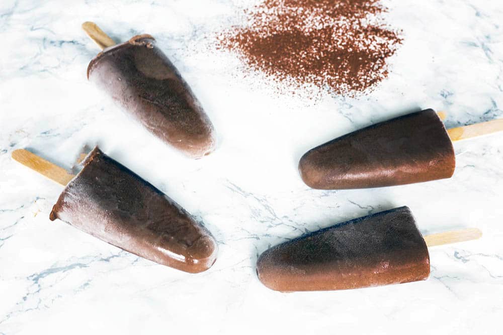 orange chocolate popsicles on white background