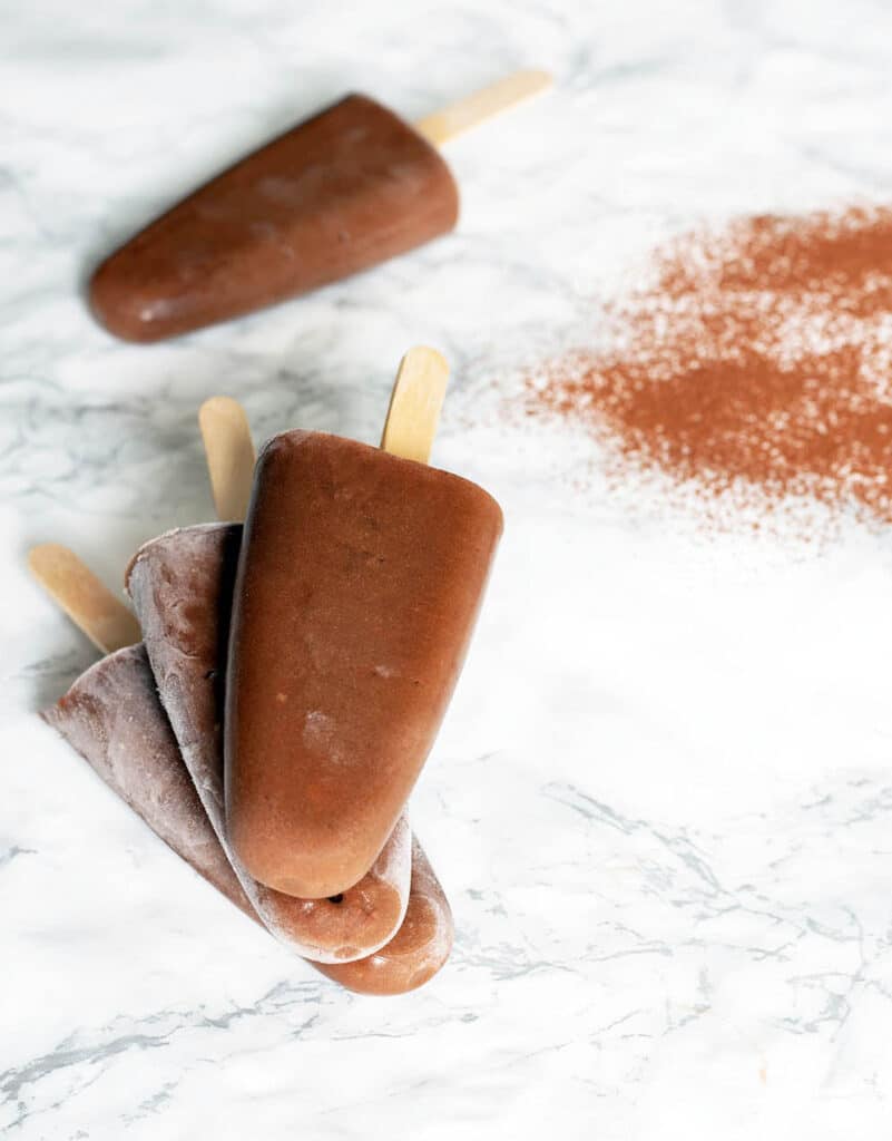 orange chocolate popsicles on white background