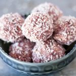 close up of raspberry bliss balls in blue bowl