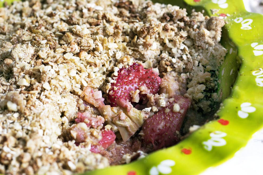 strawberry and rhubarb crumble in green dish