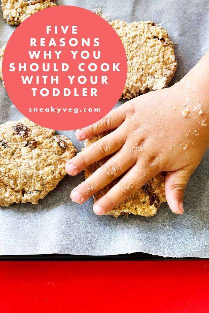 child's hand flattening cookies