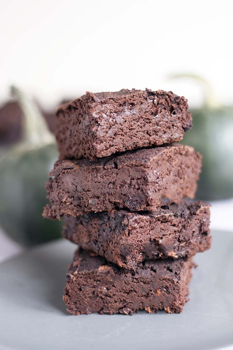 stack of four pumpkin brownies with green pumpkins in background