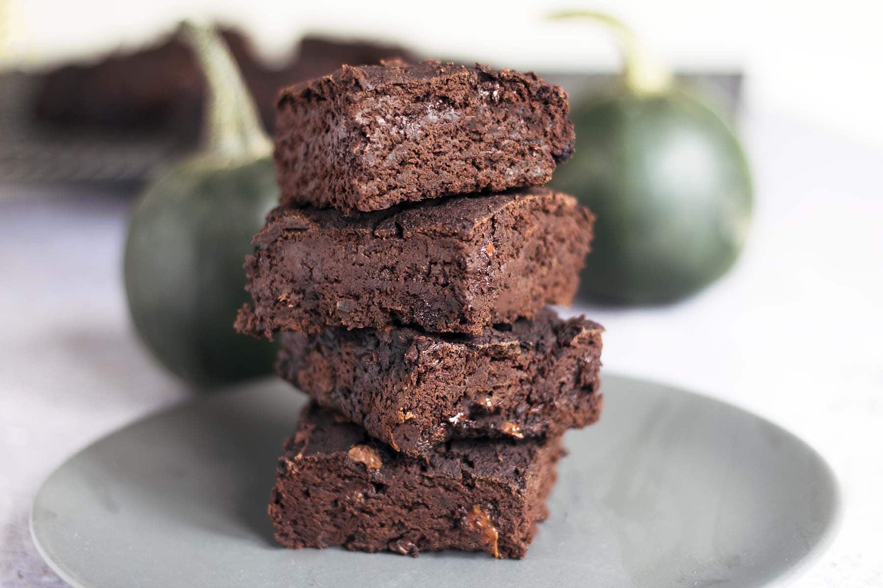 stack of four pumpkin brownies with green pumpkins in background