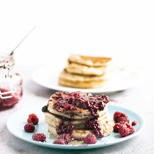 stack of banana almond pancakes with berry topping