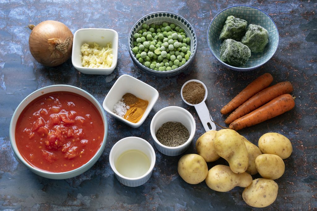 ingredients for Mixed vegetable curry on blue background