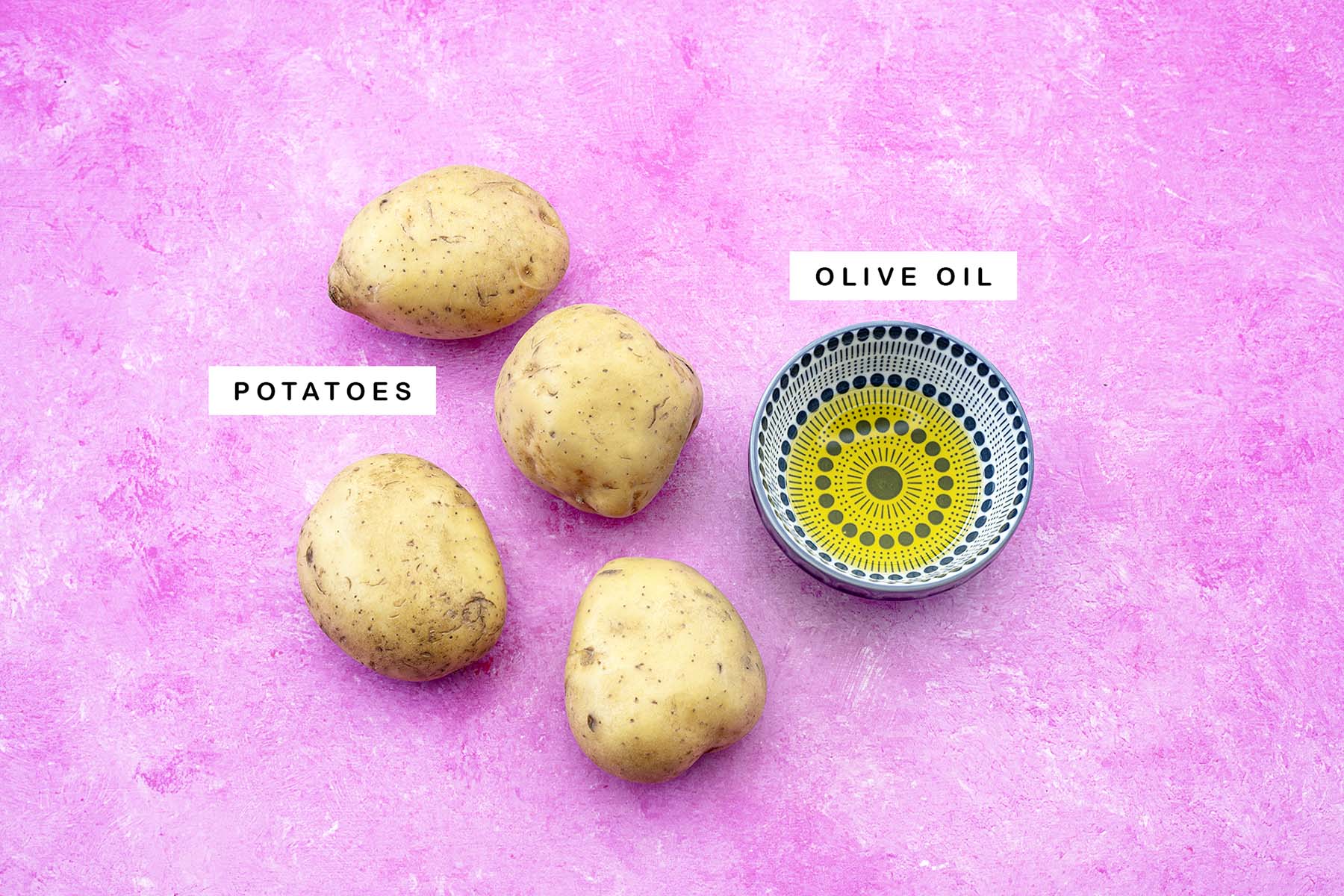 potatoes and oil on pink background