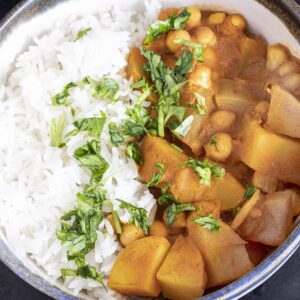 overhead shot of potato chickpea curry in bowl with rice