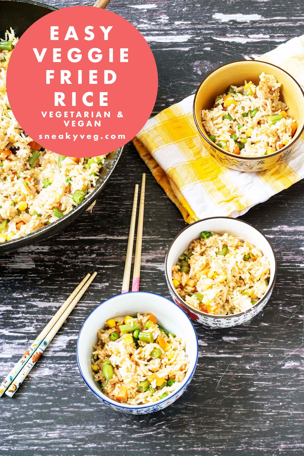veggie fried rice in wok and bowls with chopsticks