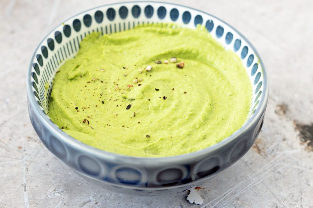 close up of pea and mint dip in blue bowl