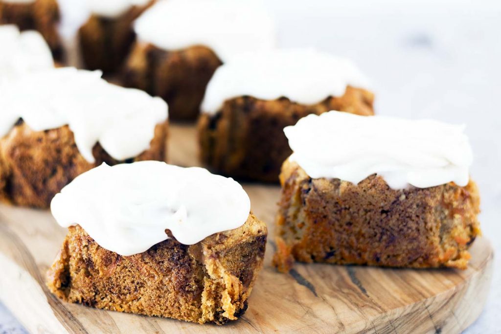 vegan carrot loaf cakes with cream cheese frosting on wooden board