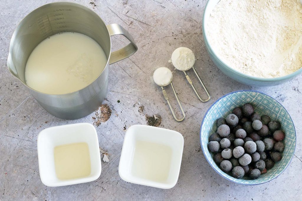 ingredients to make blueberry sheet pan pancakes on grey background