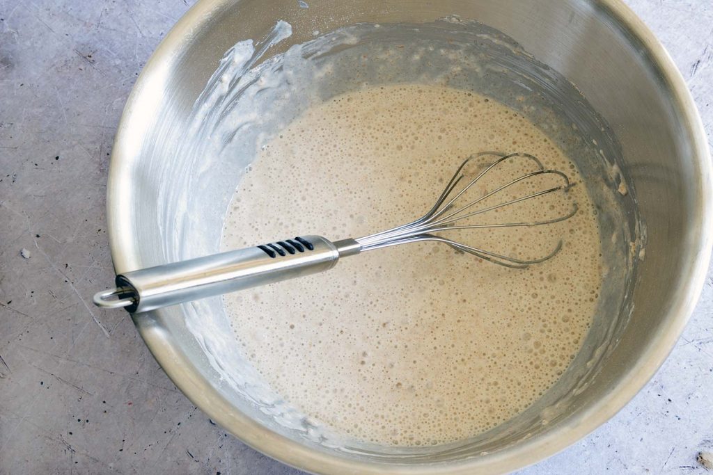 pancake batter in metal mixing bowl with whisk