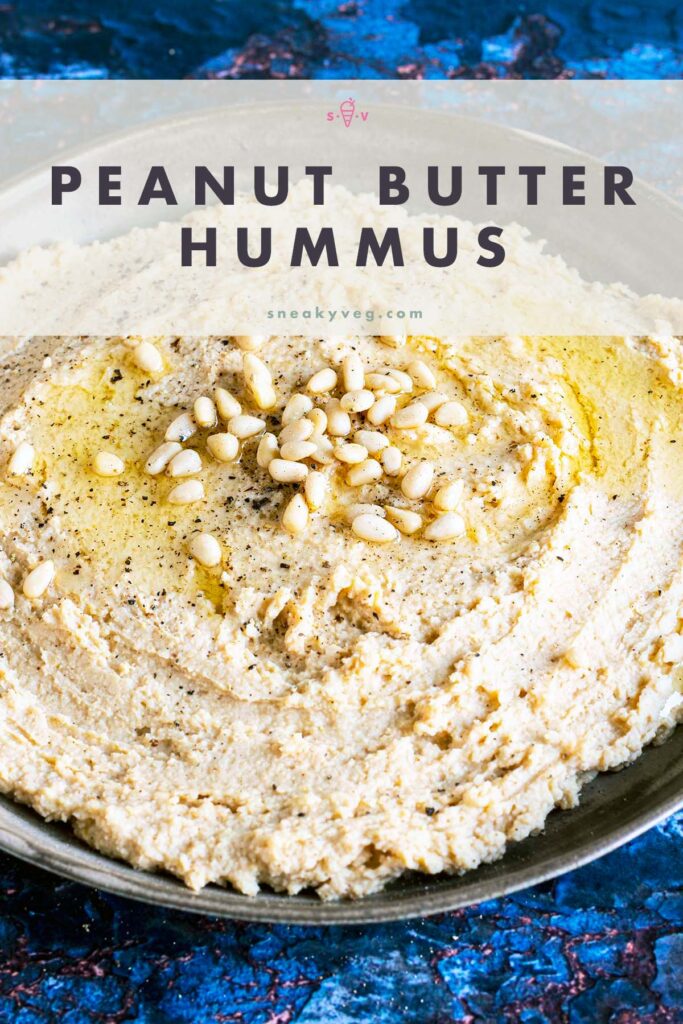 peanut butter hummus on plate topped with oil and pine nuts