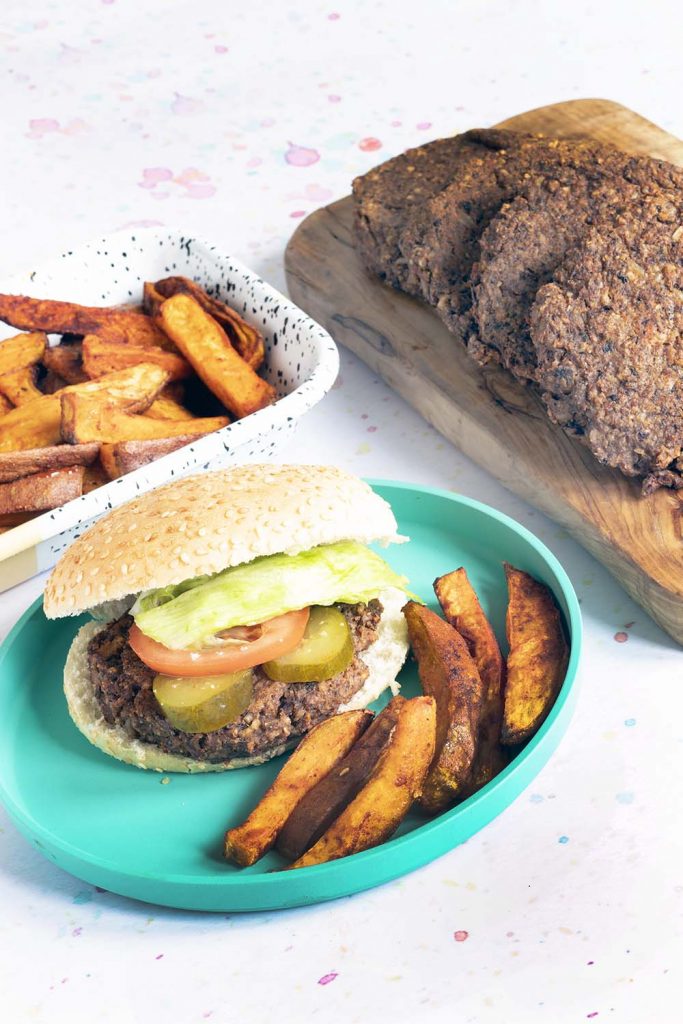 vegan mushroom burgers with sweet potato wedges on blue plate