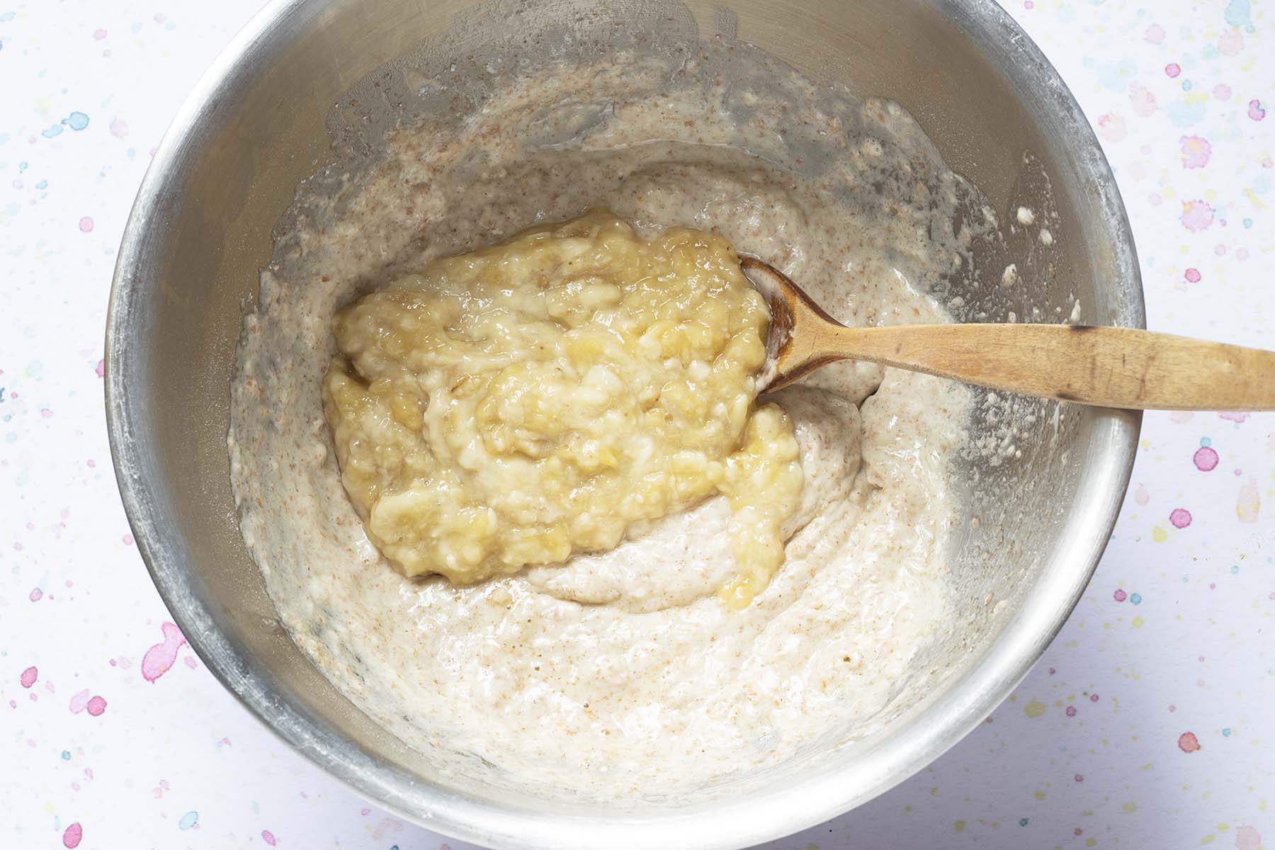 muffin batter in bowl with mashed banana