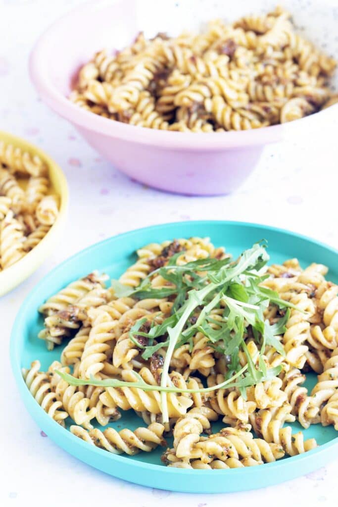 portrait photo of fusilli pasta with sundried tomato pesto and rocket