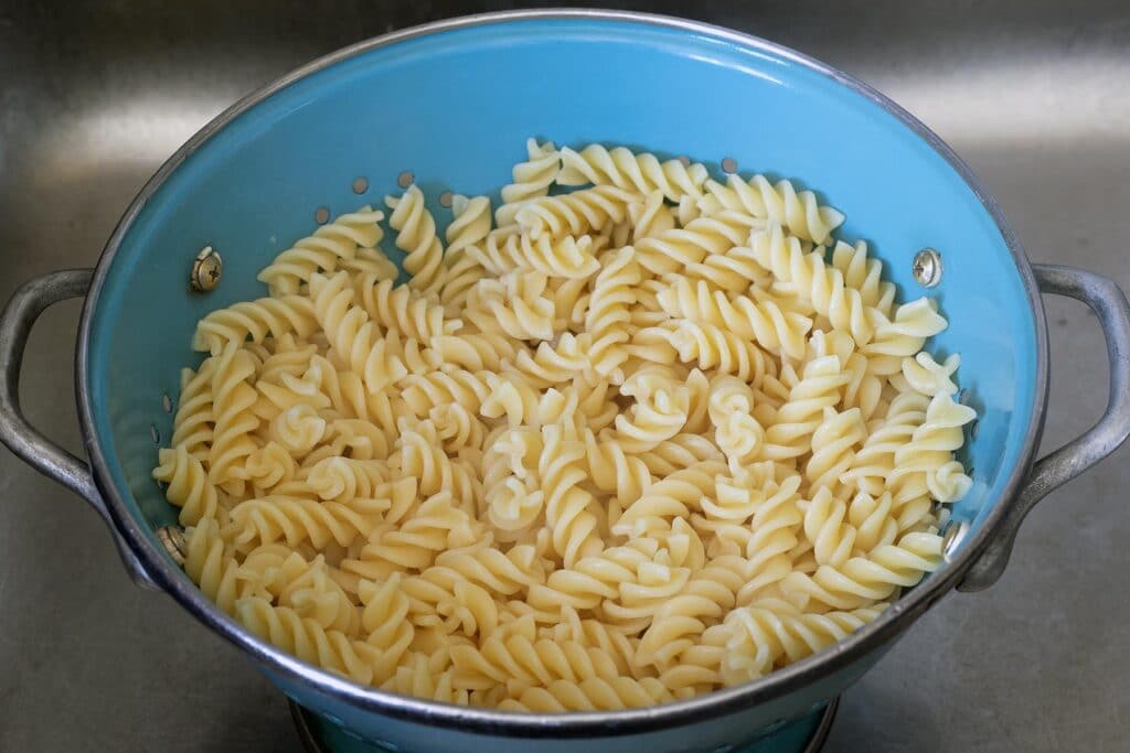 cooked pasta in blue colander