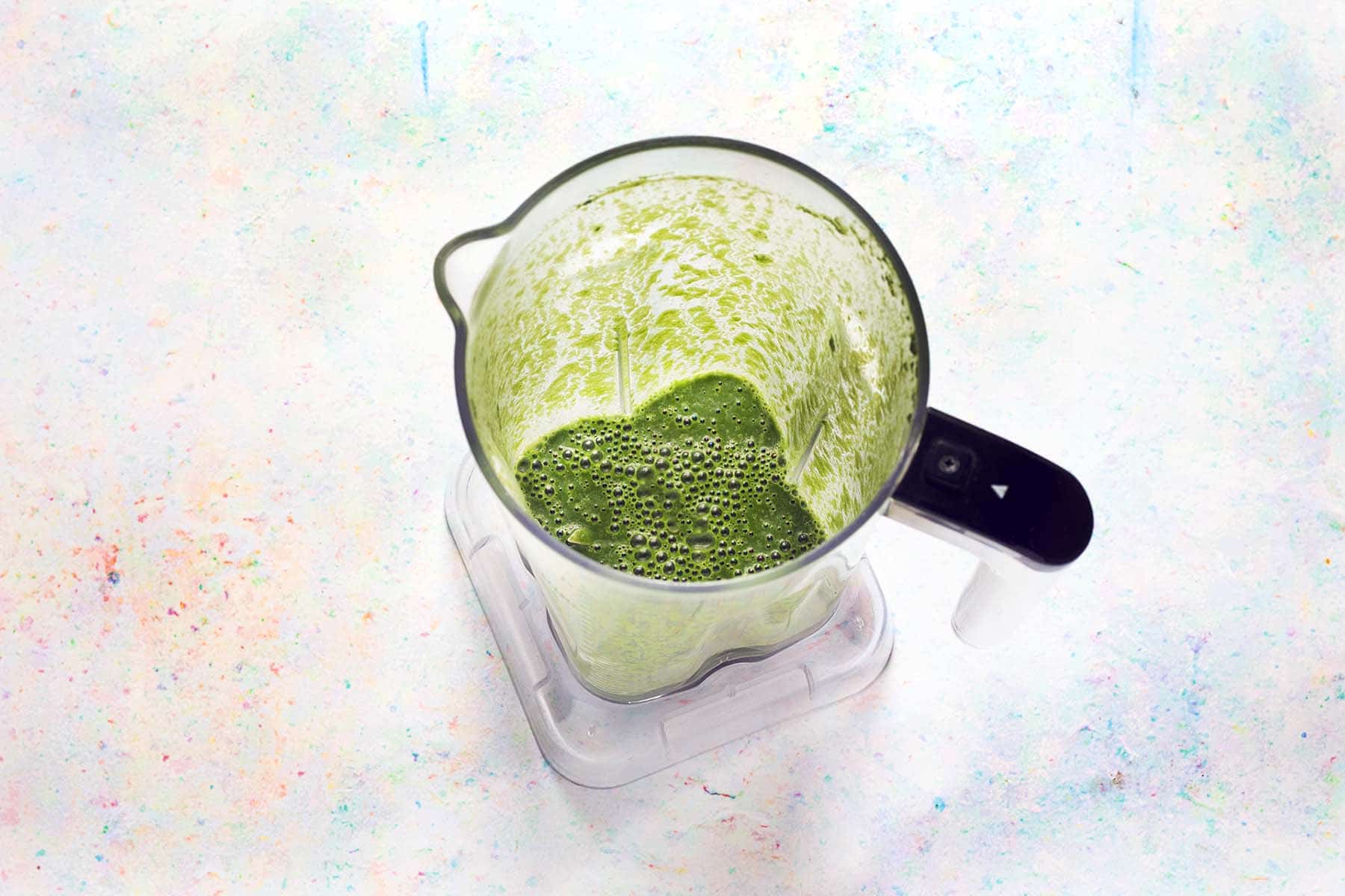 blended spinach and oat milk in blender jug