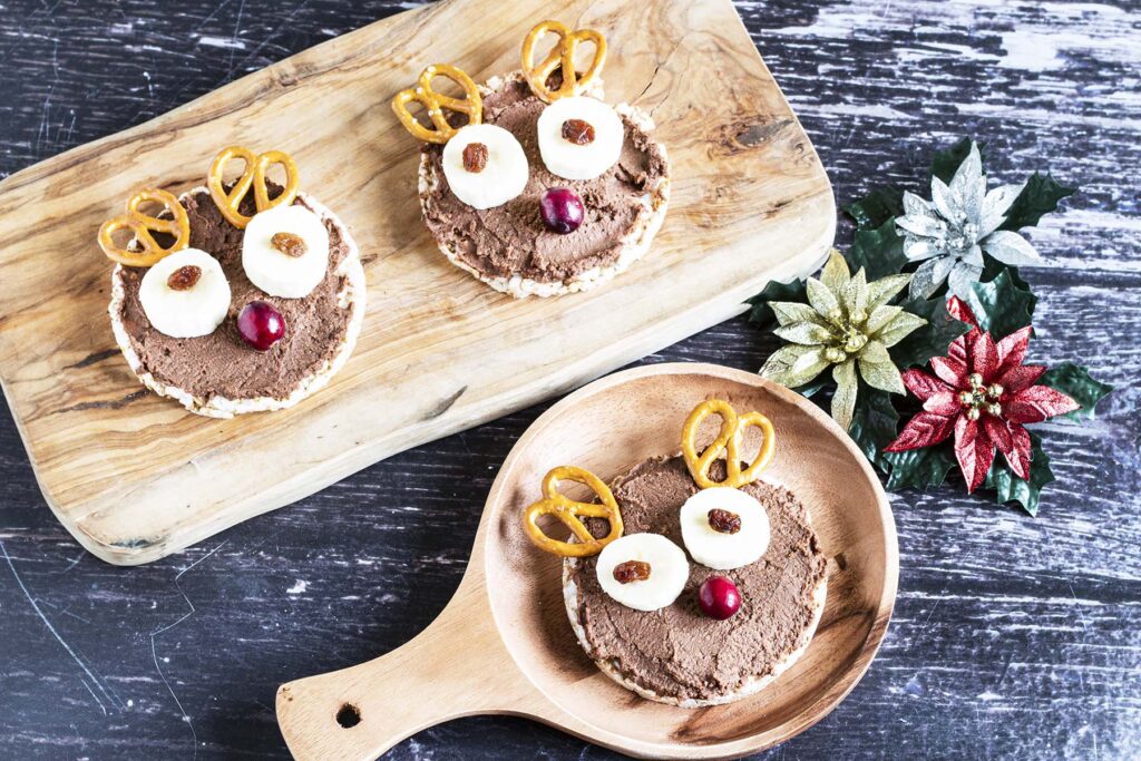 rice cake reindeer face with chocolate hummus, fruit and pretzels