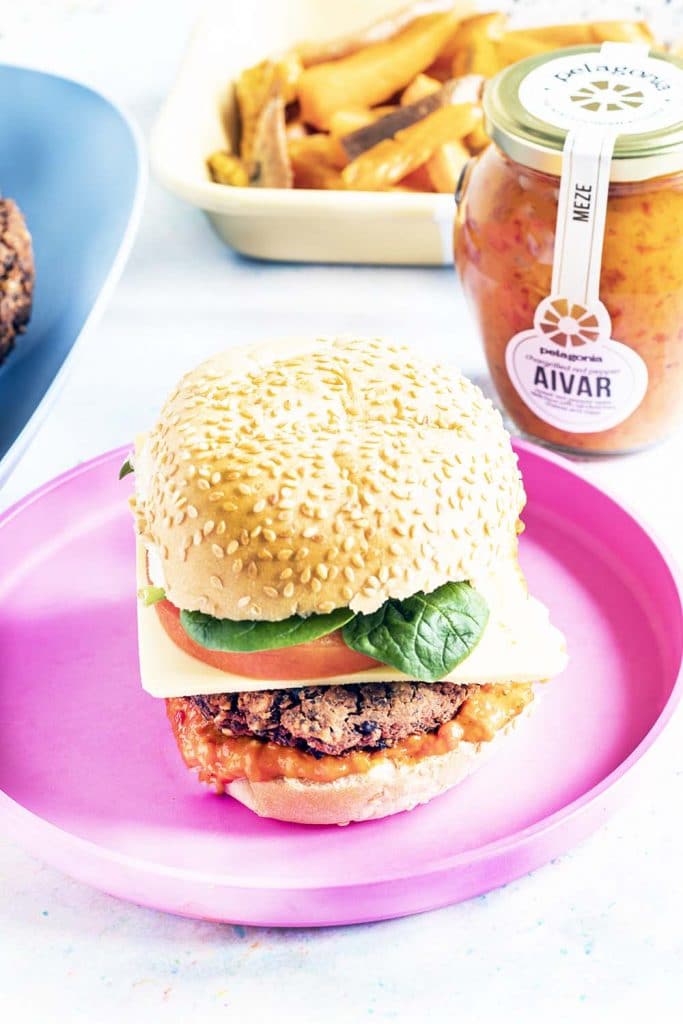 black bean burger with aivar on pink plate with wedges in background