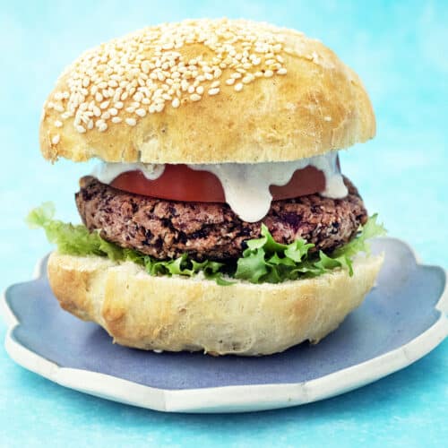 bean burger in bun on blue plate with blue background